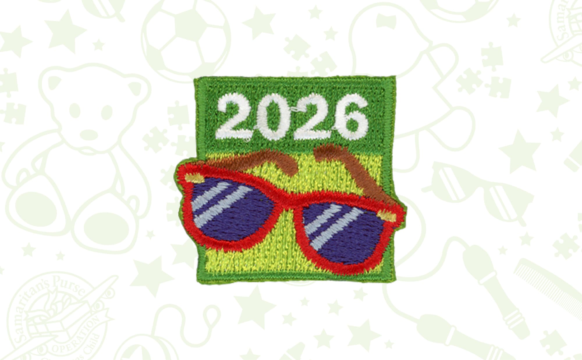 A small, embroided patch with the numbers 2026  sitting above a pair of sunglasses