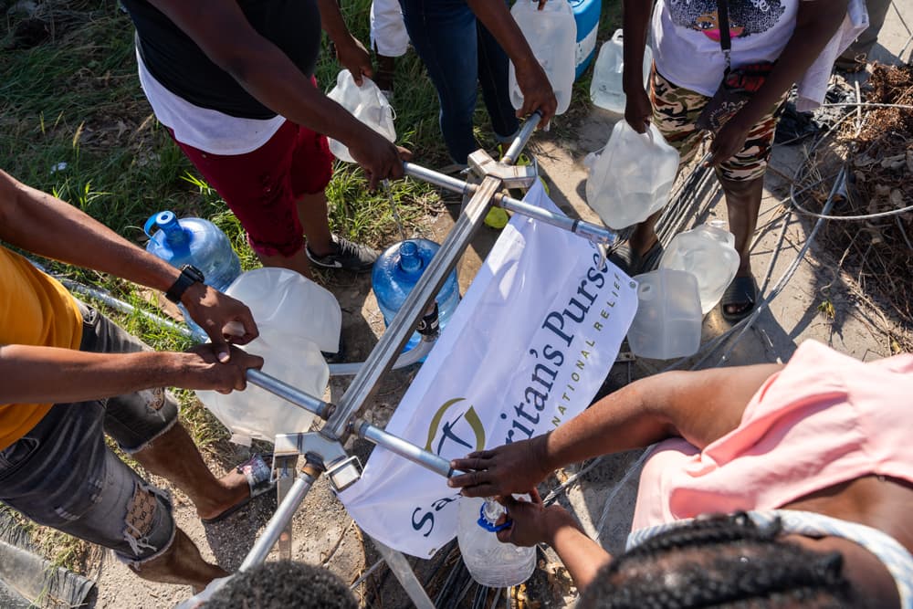 Group of Jamaican residents collecting clean water from a Samaritan’s Purse filtration system after Hurricane Melissa.