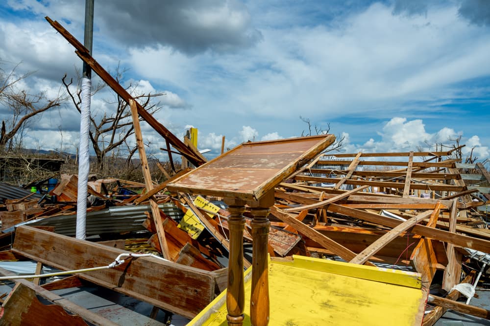 Collapsed church structure with splintered wooden beams and debris after Hurricane Melissa in Jamaica.