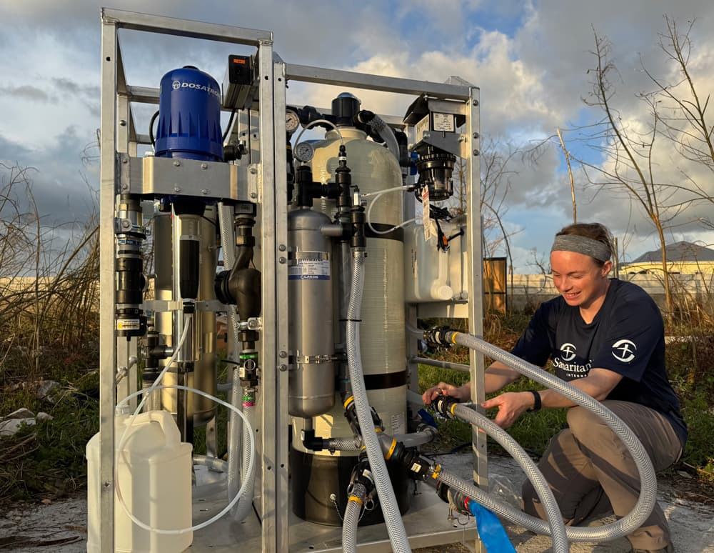 Samaritan’s Purse worker operates a water filtration system near the shoreline amid hurricane debris in Jamaica.