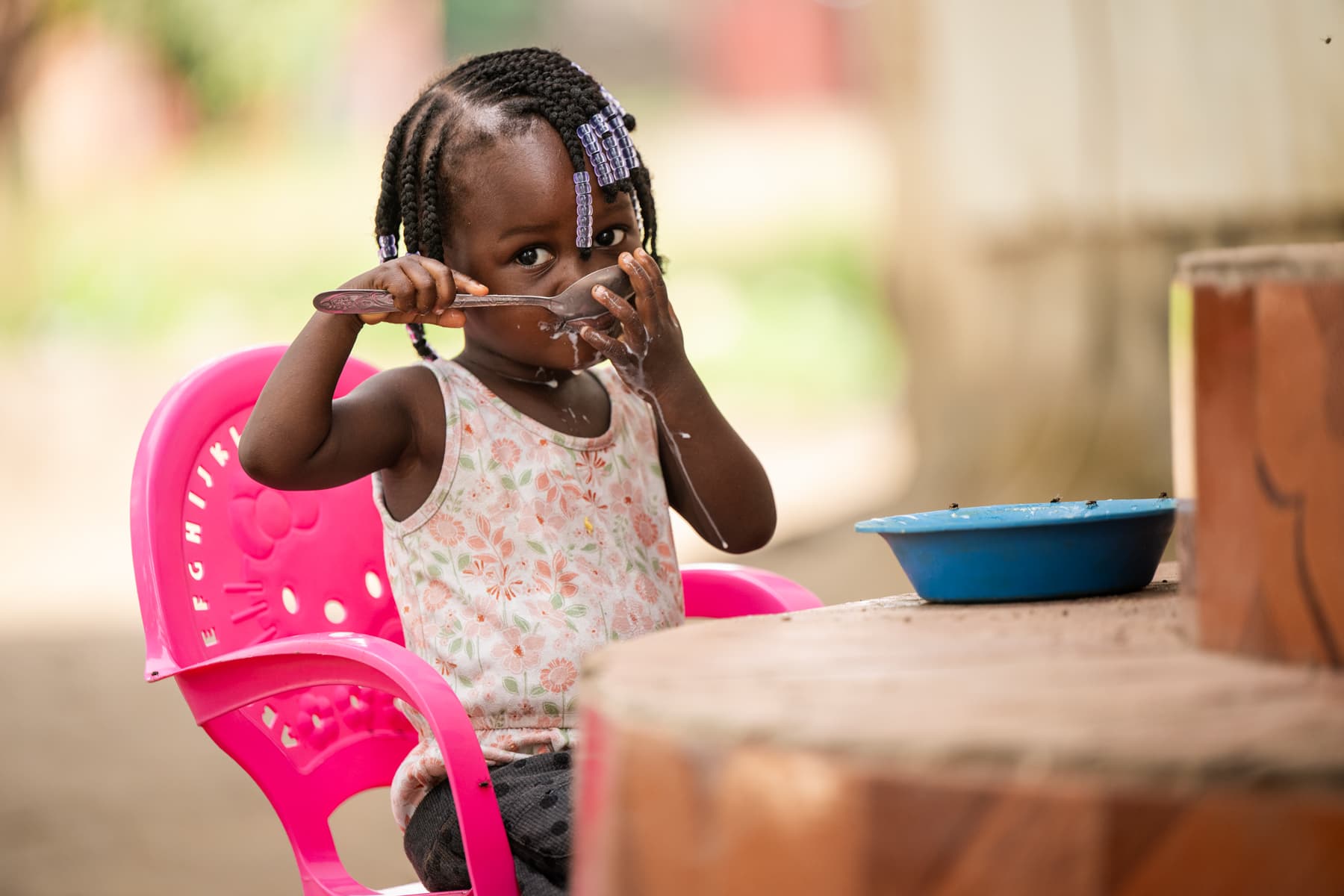 Tutu's daughter eating food with a large spoon.
