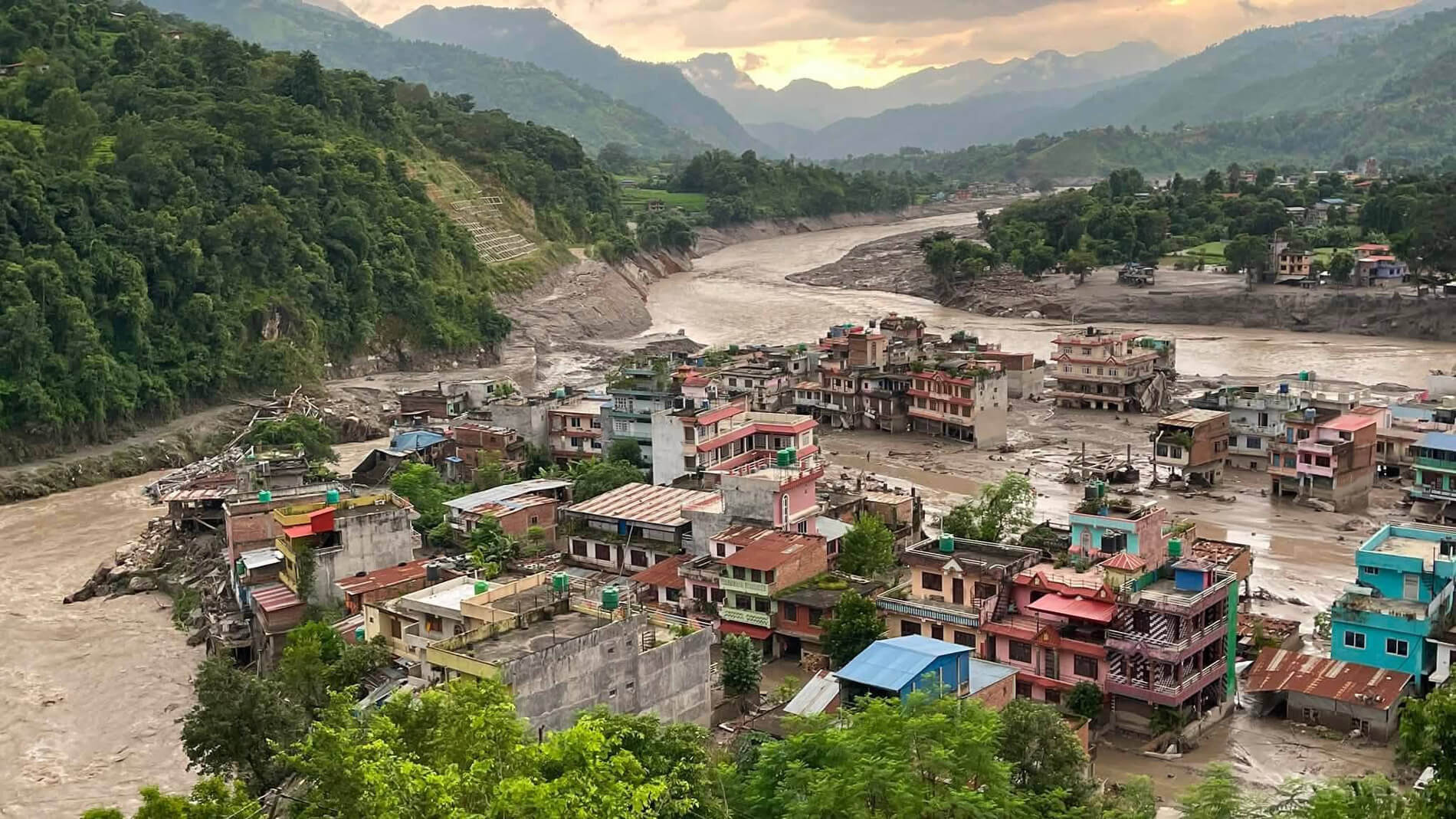 Mud and debris surround homes and other structures in mountainous, flood ravaged areas of Nepal.