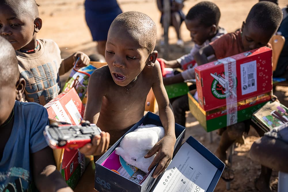 A Himba child is amazed by their gifts