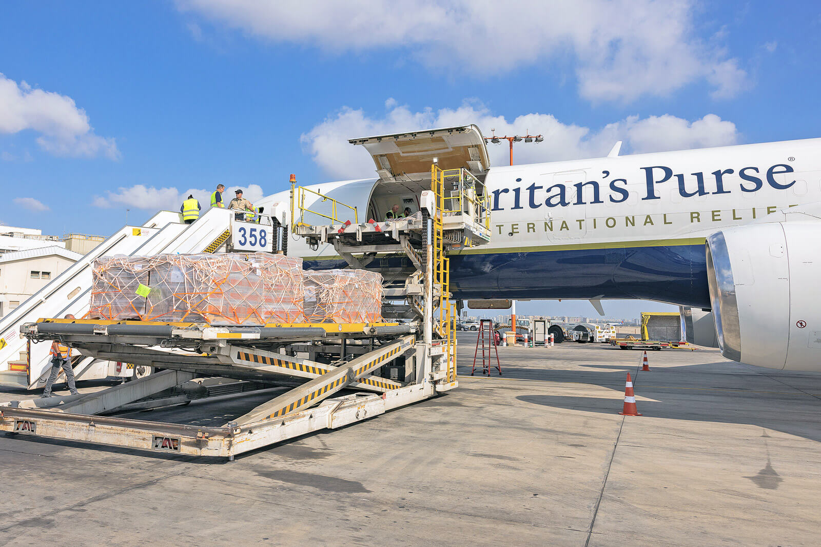 workers loading pallets of supplemental nutrition packets onto a Samaritan's Purse plane.