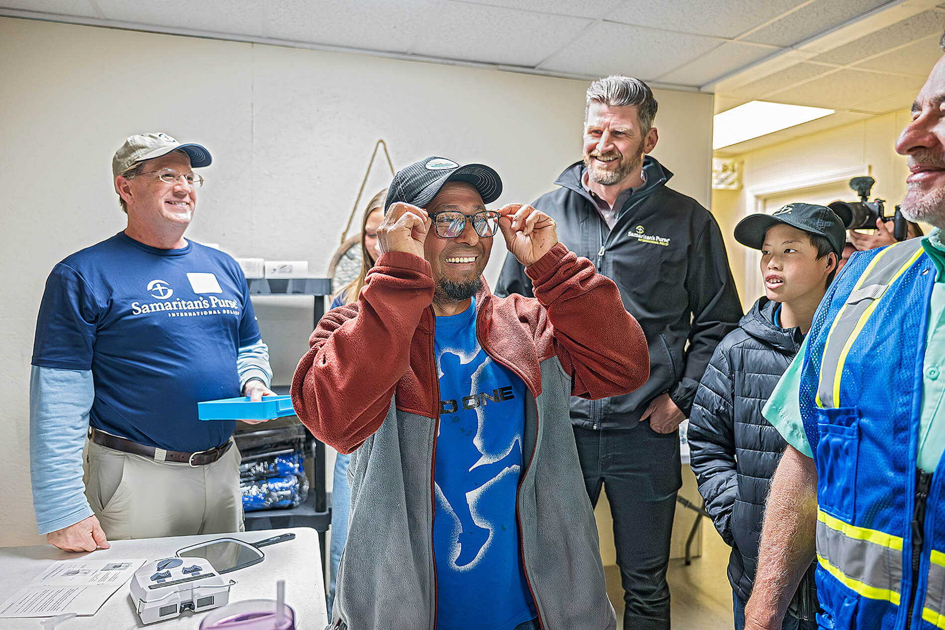 A man smiles while trying on his new prescription glasses provided by Samaritan's Purse after receiving care