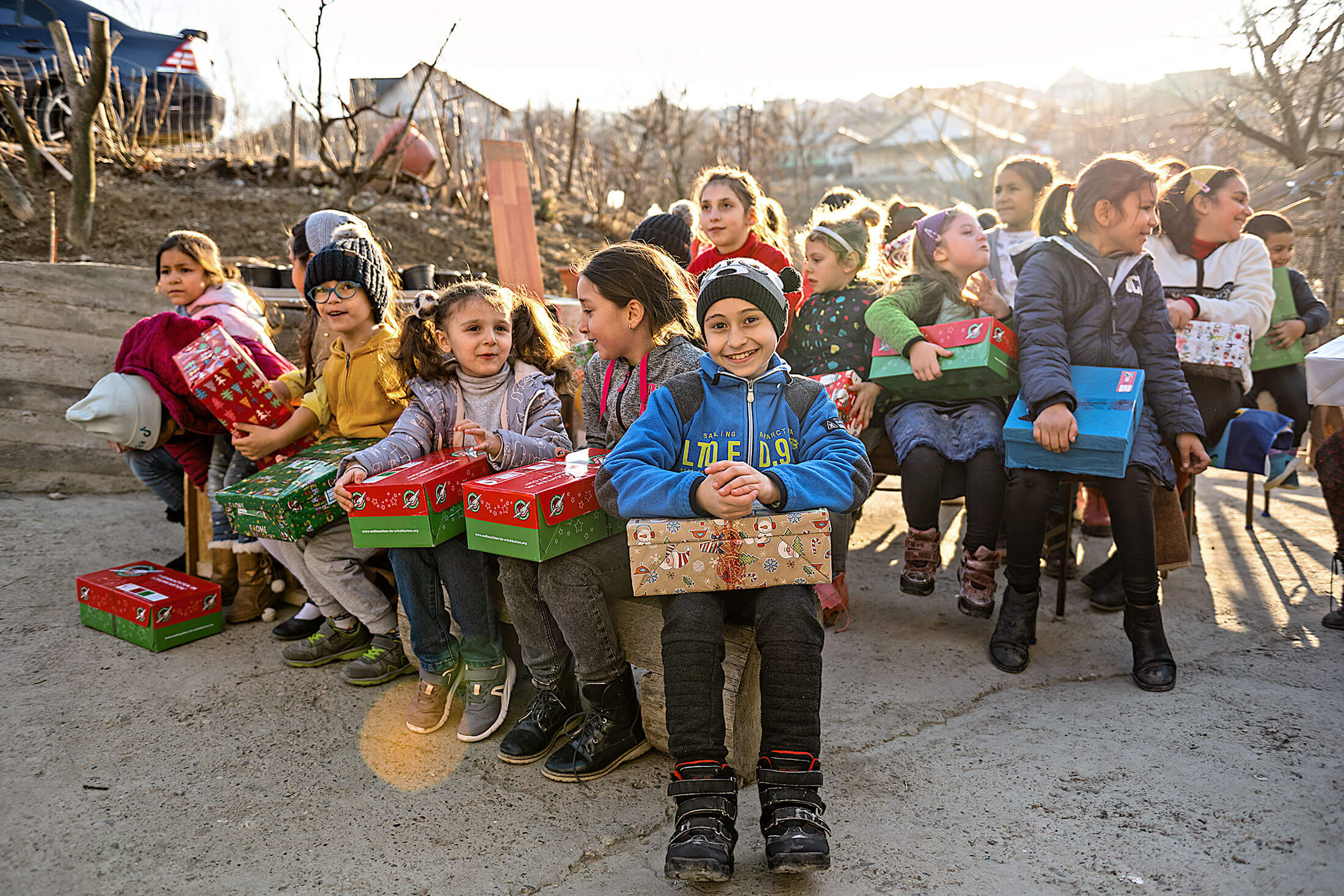 Two girls grinning while holding their Operation Christmas Child boxes and toys.