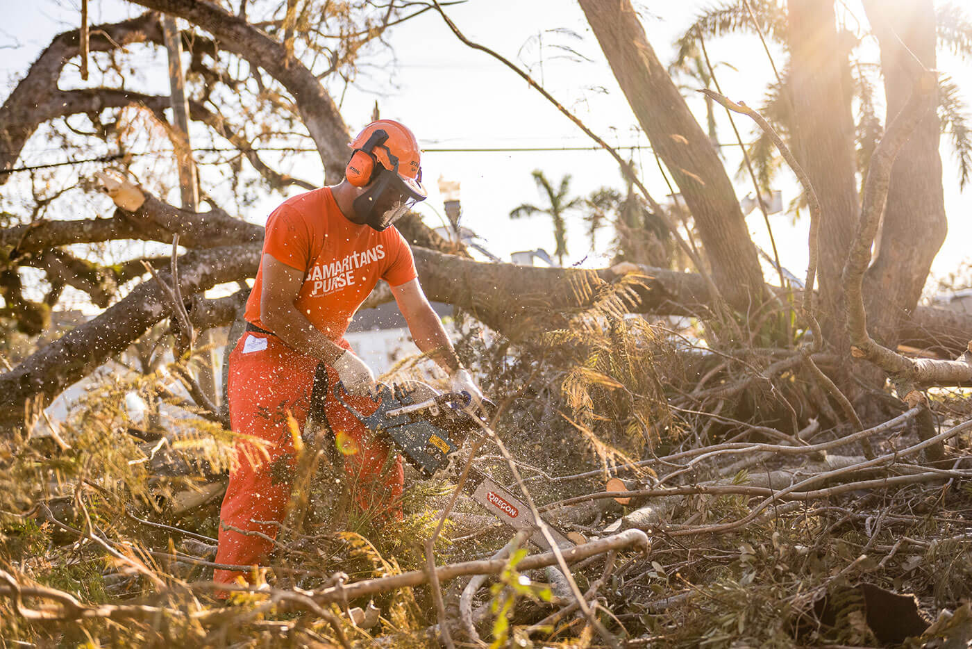 A Samaritan's Purse volunteer sawing a tree.