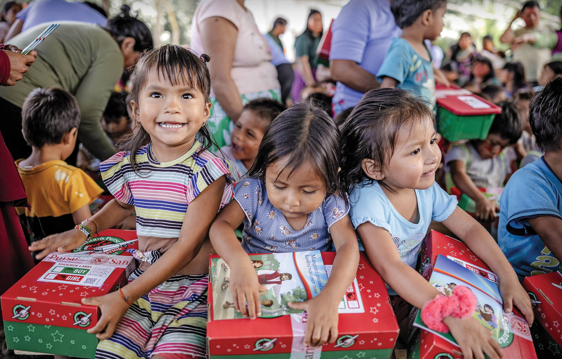 Smiling children opening their Operation Christmas Child boxes