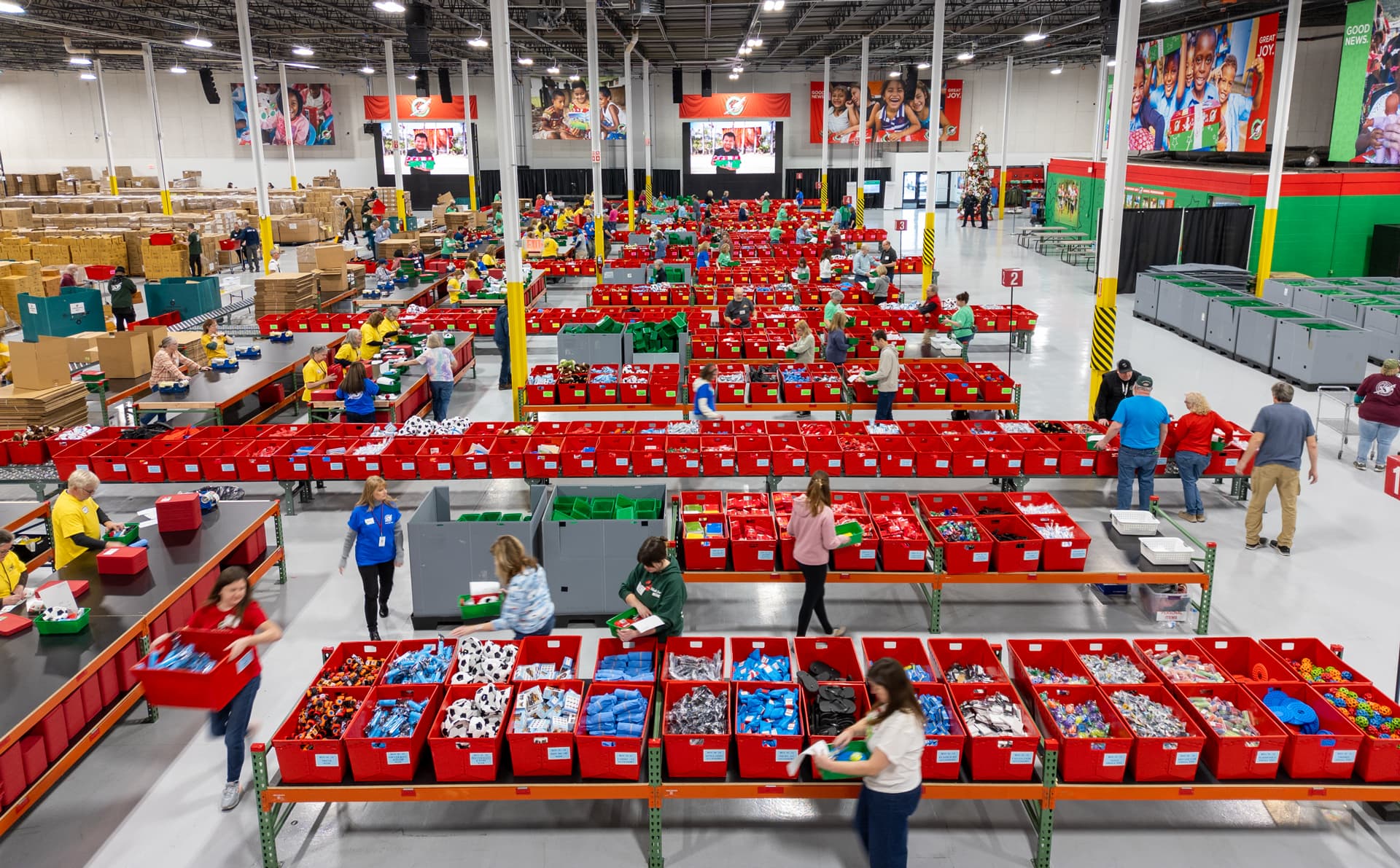 Aerial view of voluteers at a processing center packing shoeboxes for Build A Shoebox Online