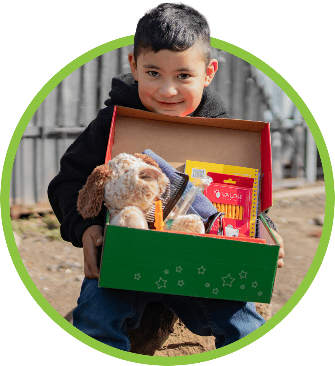 Young smiling boy holding shoebox gift from Operation Christmas Child
