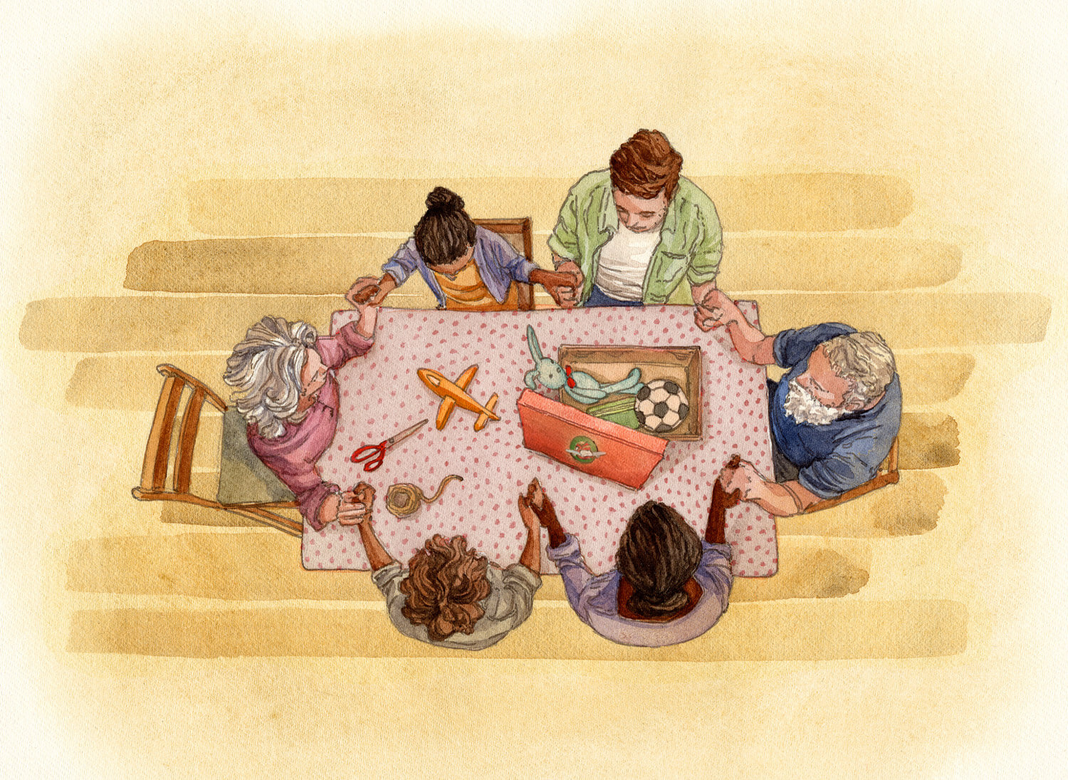 a family praying around a table with shoebox packing materials and toys on it