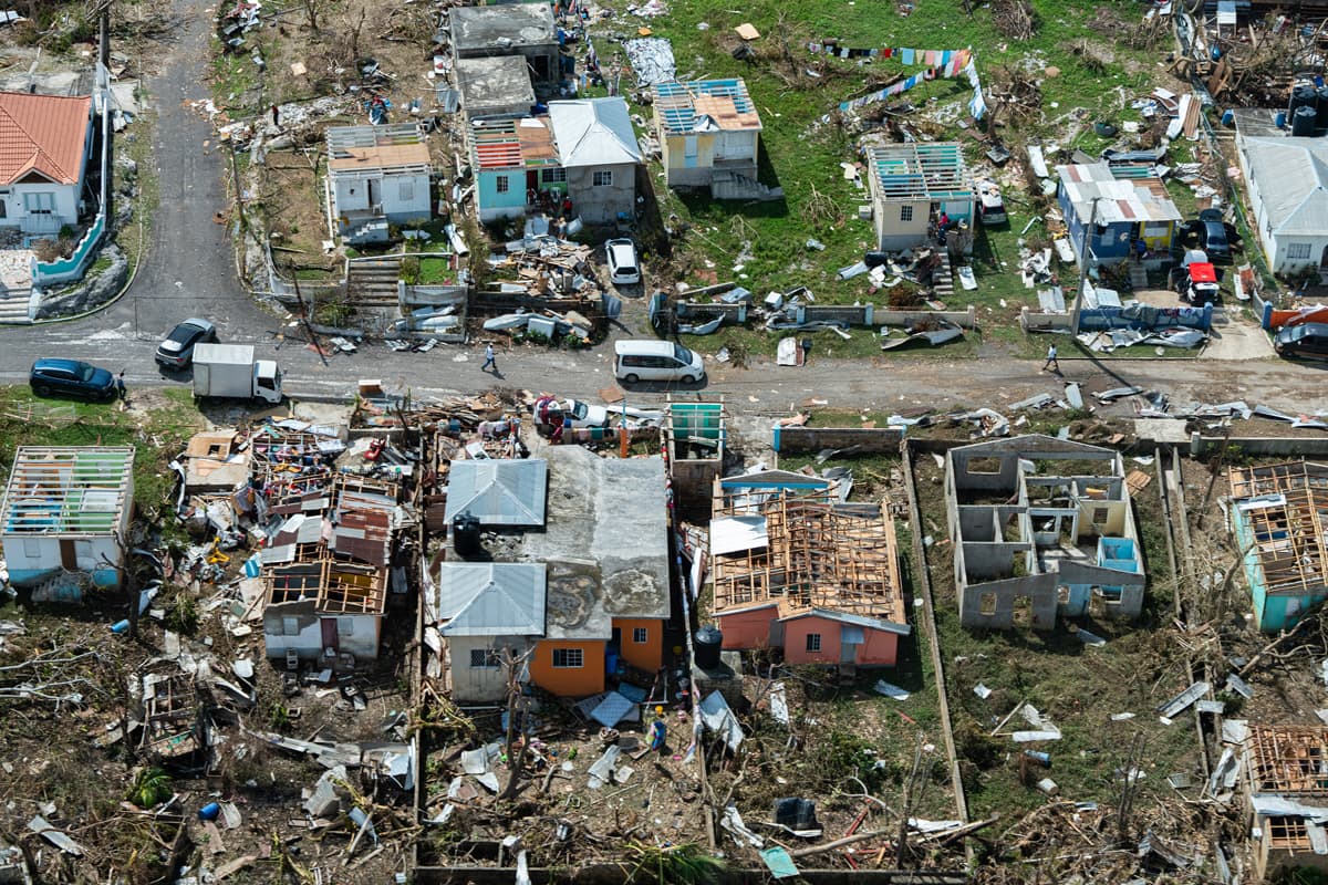 Aerial view of the destruction left from Hurricane Melissa in a Jamaican neighborhood with rooftops torn from homes and debris scattered around the homes and streets