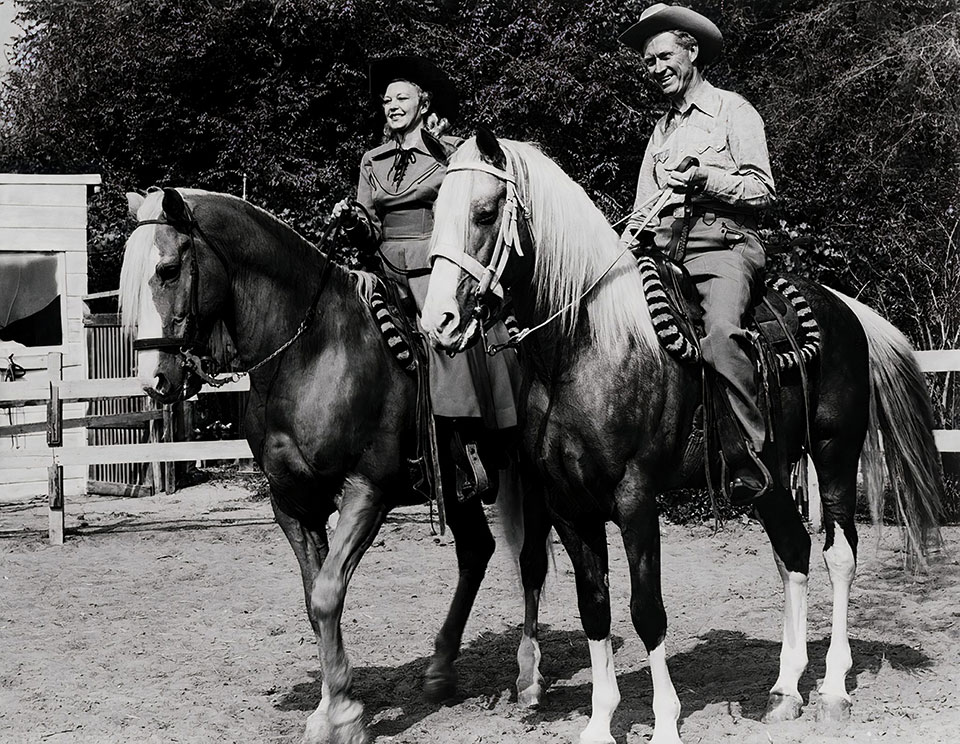 Man and woman on horses.